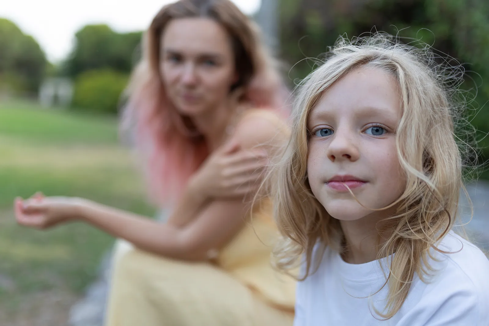 boy-foreground-stares-intolens-mum-pink-hair-background-parenting-under-pressure-free-support-centacare-south-west-nsw