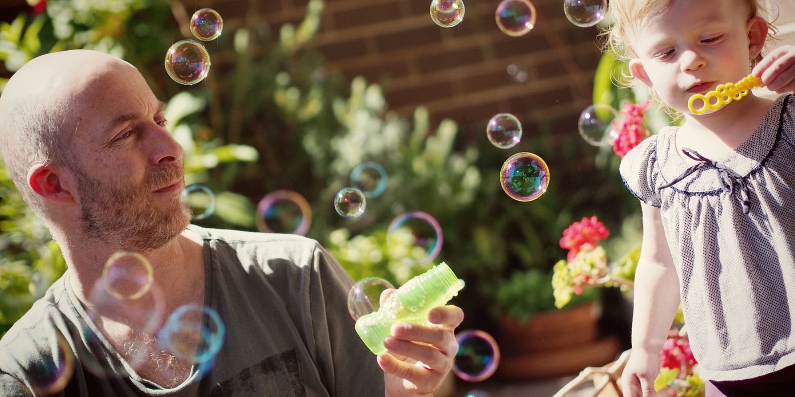 Dad and child blowing bubbles - NDIS Early Childhood Intervention | Centacare South West NSW